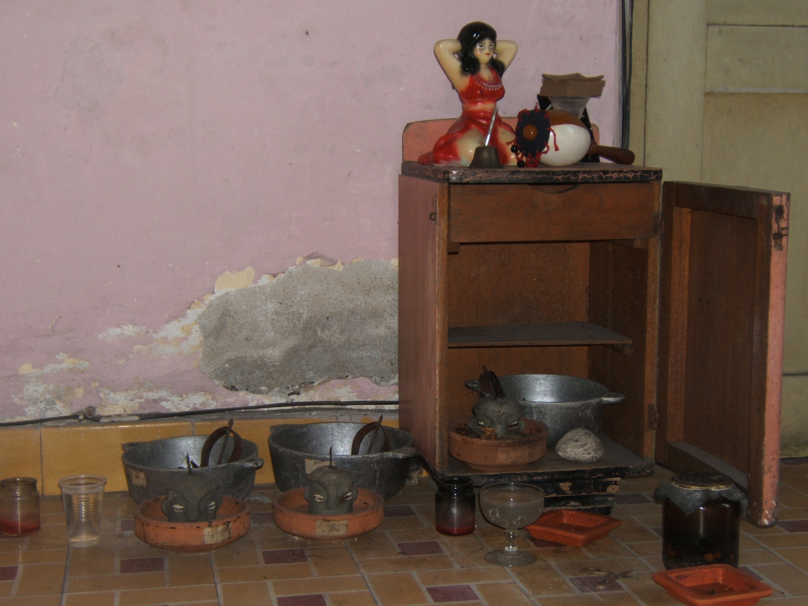 Figure 2. The oricha Eleggua’s “little house” sits next to the front door, where each household member’s Eleggua and warrior orichas can protect the house. Mirta’s “Gypsy woman” spirit is represented by the plaster statue atop the “little house.” Santiago de Cuba, August 2008. Photograph by author.