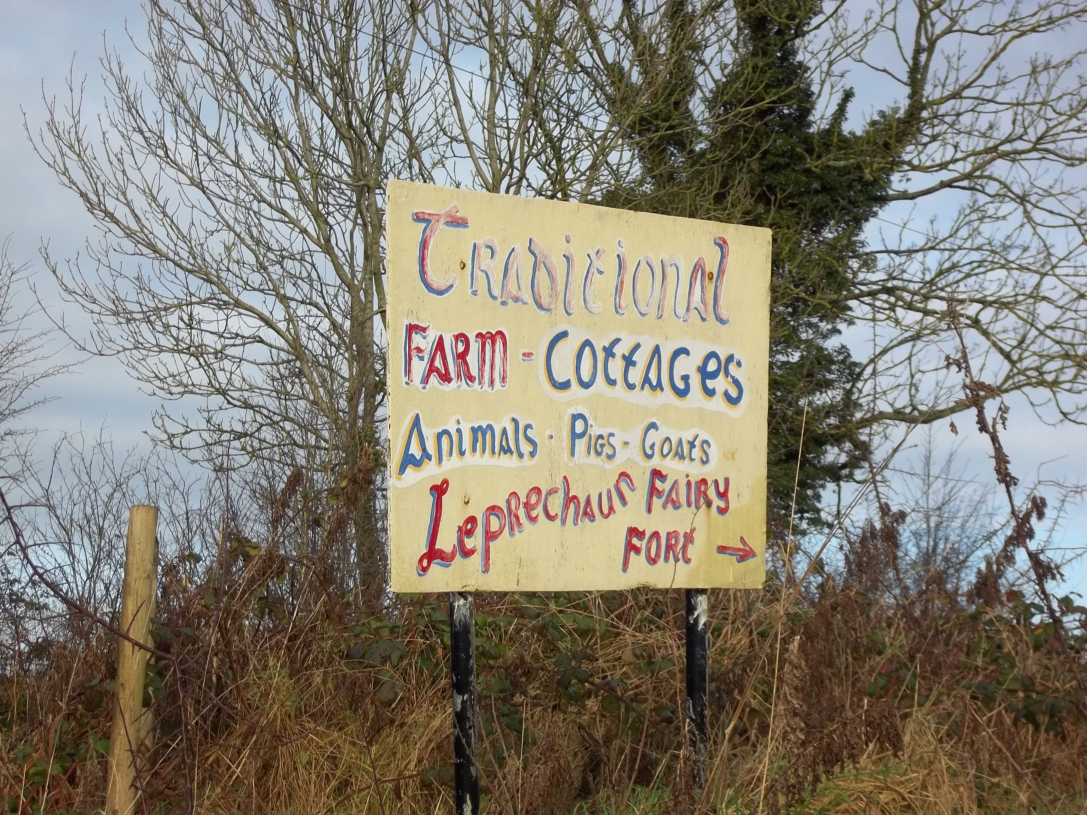 Handpainted Sign for Fairy Fort Farm that is labelled "Traditional Farm, cottages, animals, pies, goats, Leprechaun Fairy Fort"